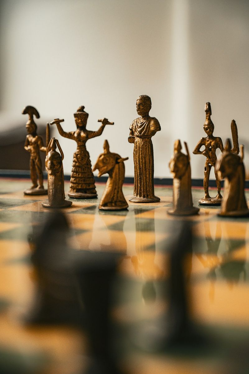 Bronze ancient chess pieces arranged on a board, evoking Molinism's analogy of God as a master chess player who achieves his purposes through knowledge rather than force