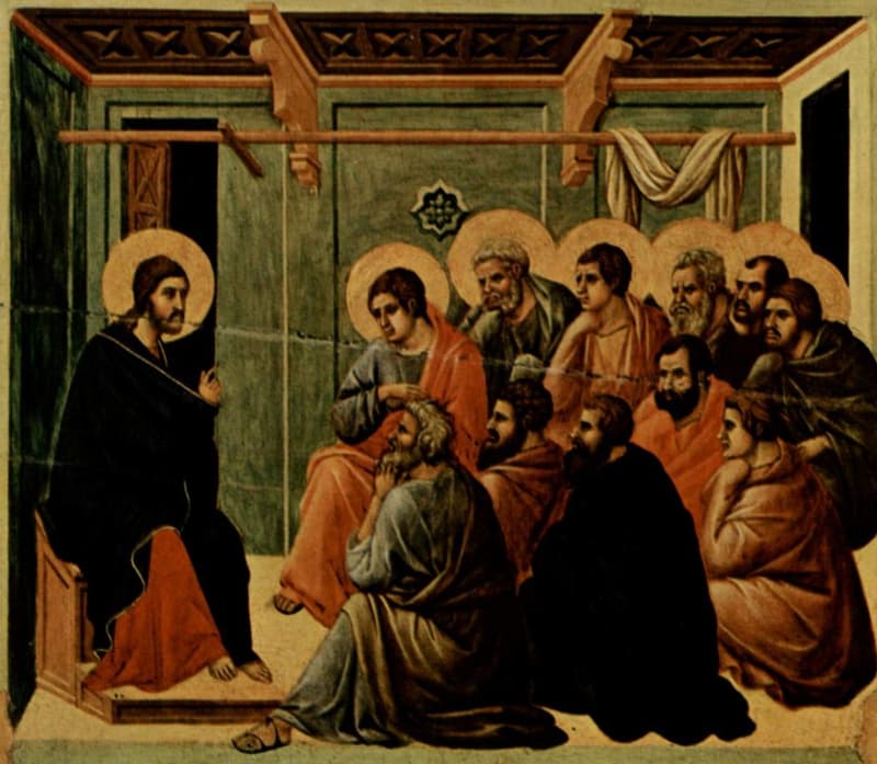 Duccio's painted panel of Christ, seated at left in a dark robe, speaking to the eleven haloed apostles gathered closely before him in a green-walled room.
