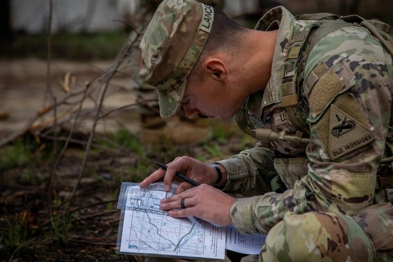 A Soldier plots points on a terrain map during land navigation training at Fort Benning. U.S. Army photo by PFC Lilyanna Martinez.