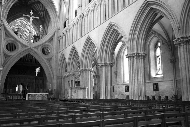 Gothic cathedral interior with soaring ribbed vaults and rows of pews, evoking the medieval scholastic world of Peter Abelard and 12th-century theology