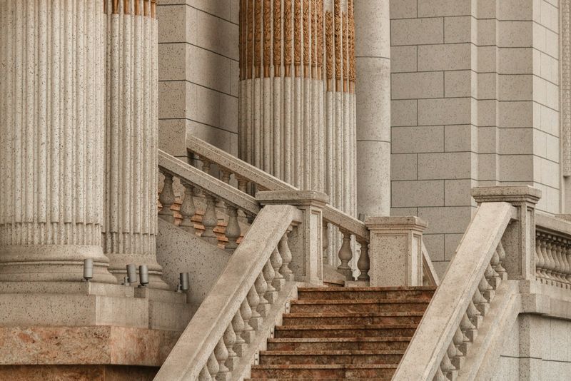 Stone staircase rising between classical columns at a courthouse-style building