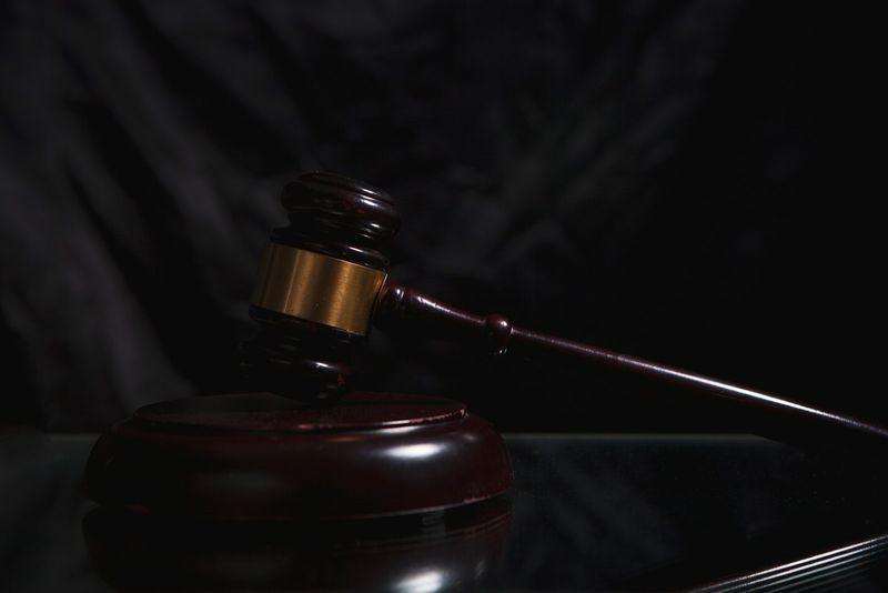 A wooden gavel resting on a dark surface