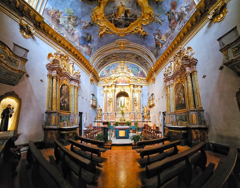 Interior of a baroque Catholic church with gilded altar and ceiling frescoes