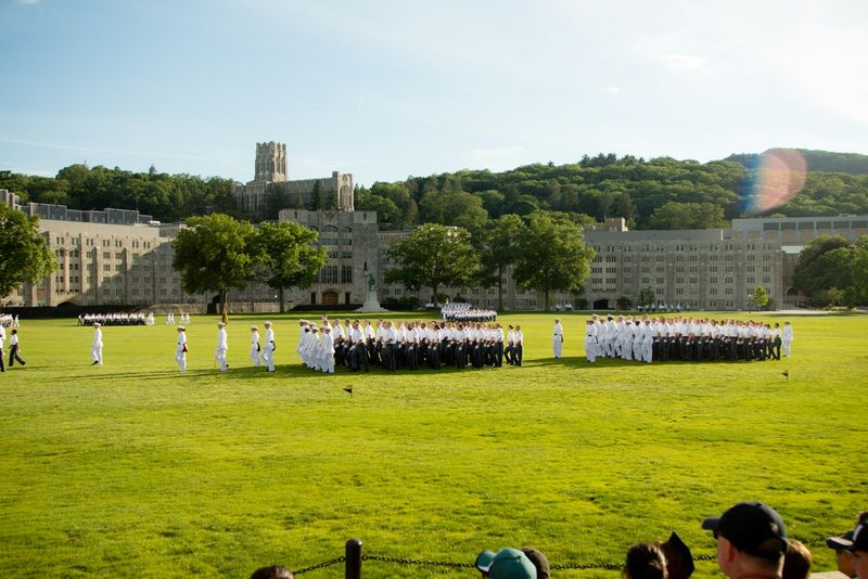 West Point cadets in dress uniforms assembled on the parade field in front of the U.S. Military Academy