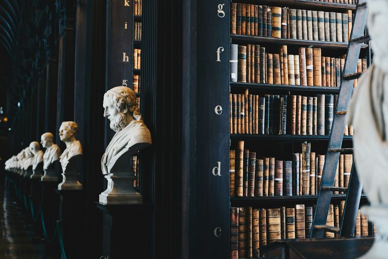 A long library hall lined with marble busts of philosophers and tall shelves of leather-bound legal volumes—evoking the legal-historical tradition out of which military criminal law developed.