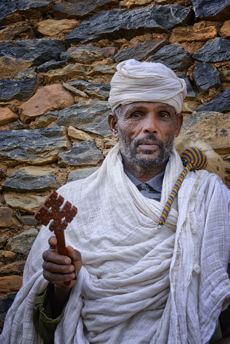 An Ethiopian Orthodox priest holding a processional cross — the Ethiopian church is one of the largest Oriental Orthodox communions.