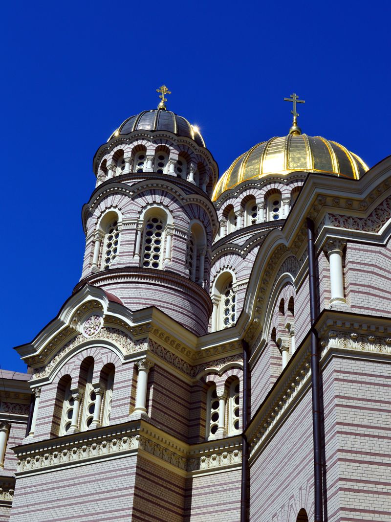 The exterior of a traditional Orthodox church with golden onion domes against a blue sky — a symbol of Eastern Christian worship.