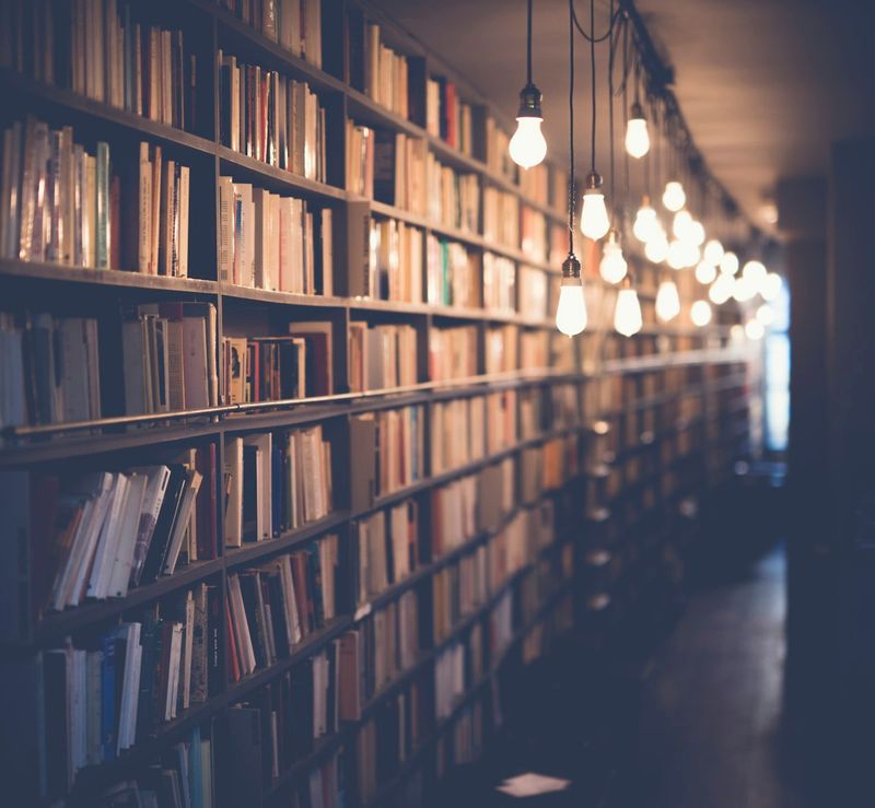 Open books on a library table, representing scholarly research and PhD-level study