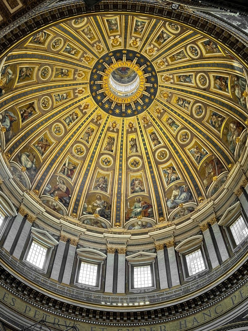 The interior dome of St. Peter's Basilica in Vatican City, with golden mosaics radiating from the oculus